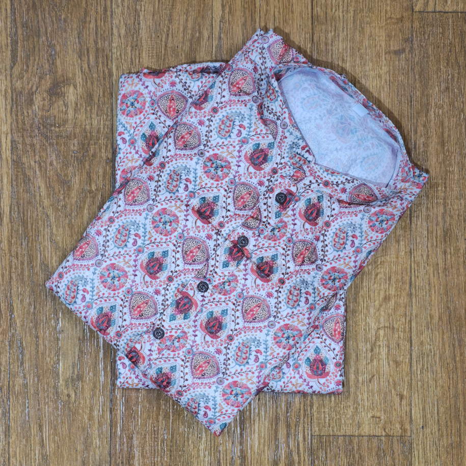Folded mandarin collar shirt with multicolor floral and paisley block print on wooden floor