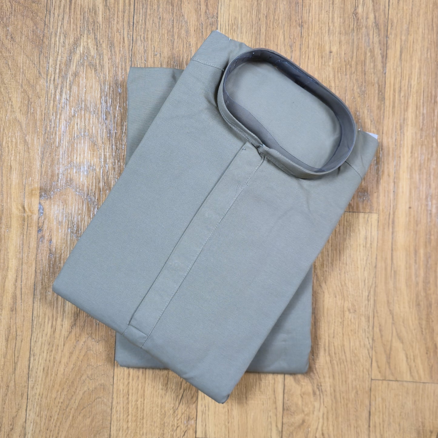Folded gray kurta on a wooden surface