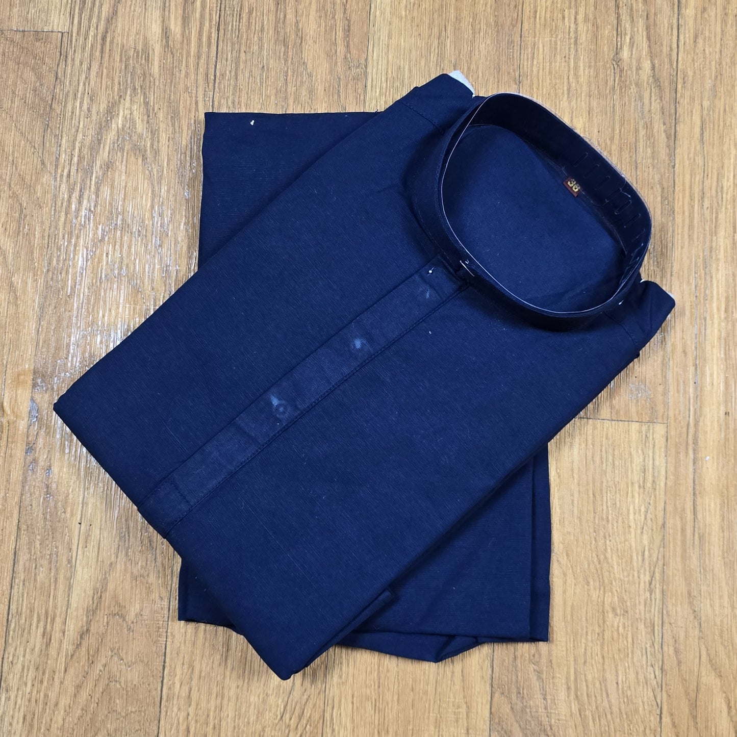 Folded Navy Blue mandarin collar Kurta on wooden floor