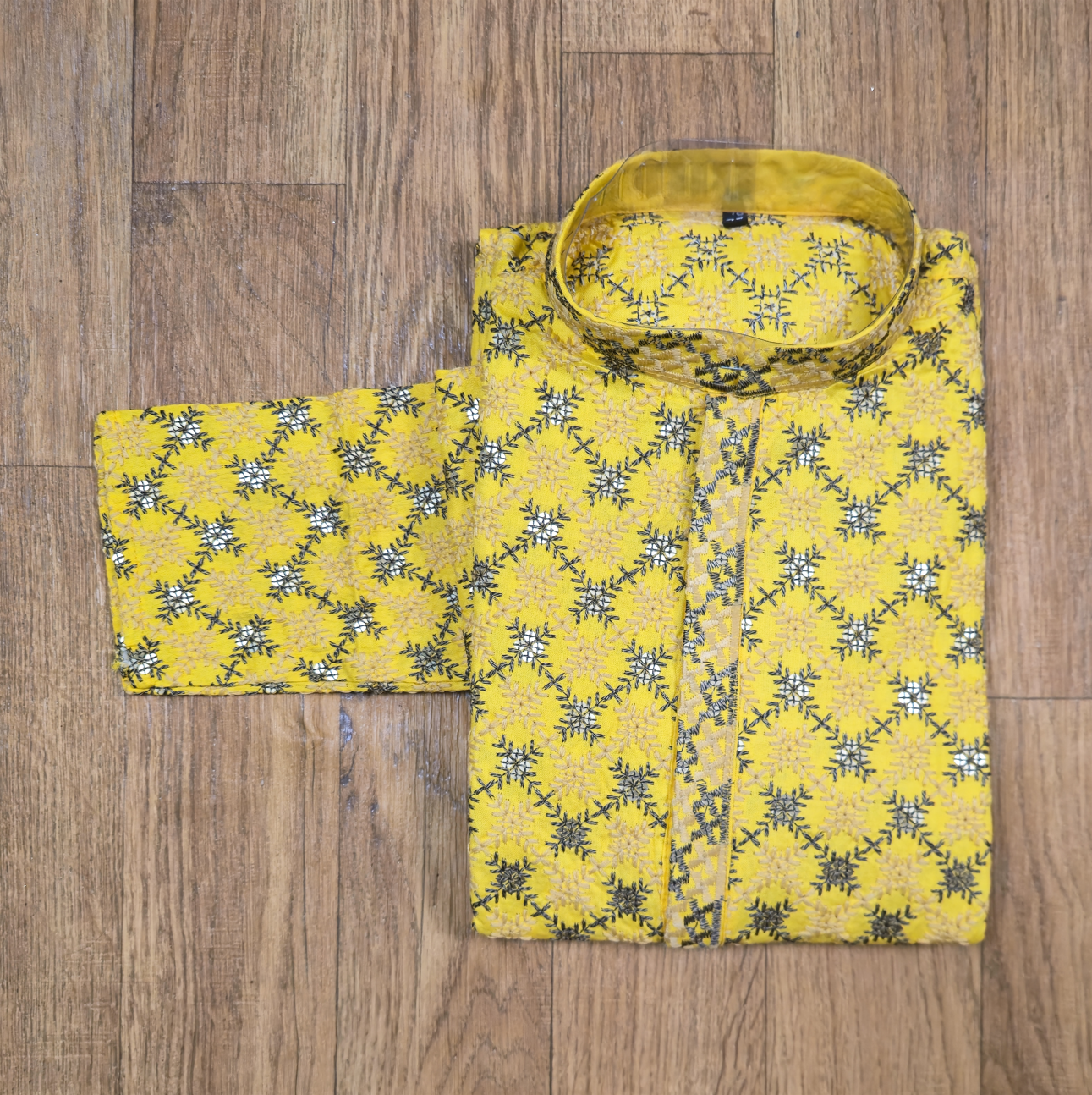 Yellow floral patterned shirt on a wooden floor