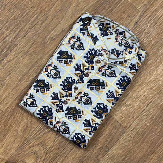 Folded mandarin collar shirt with navy blue, yellow, and maroon geometric floral print on white fabric, placed on wooden floor