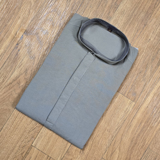 Folded gray kurta on a wooden surface