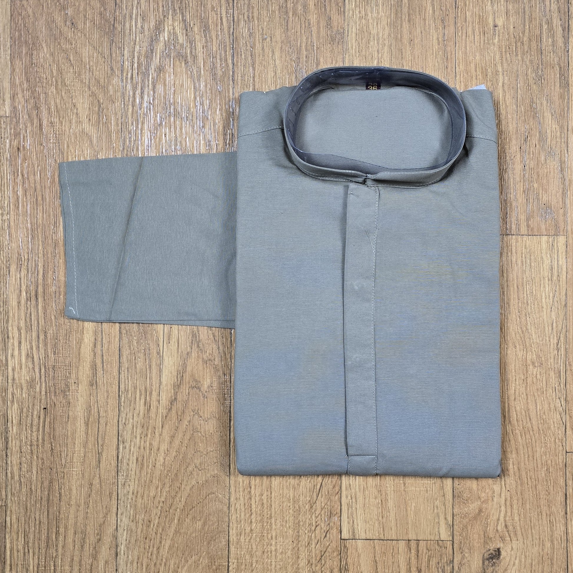 Folded gray kurta on a wooden surface