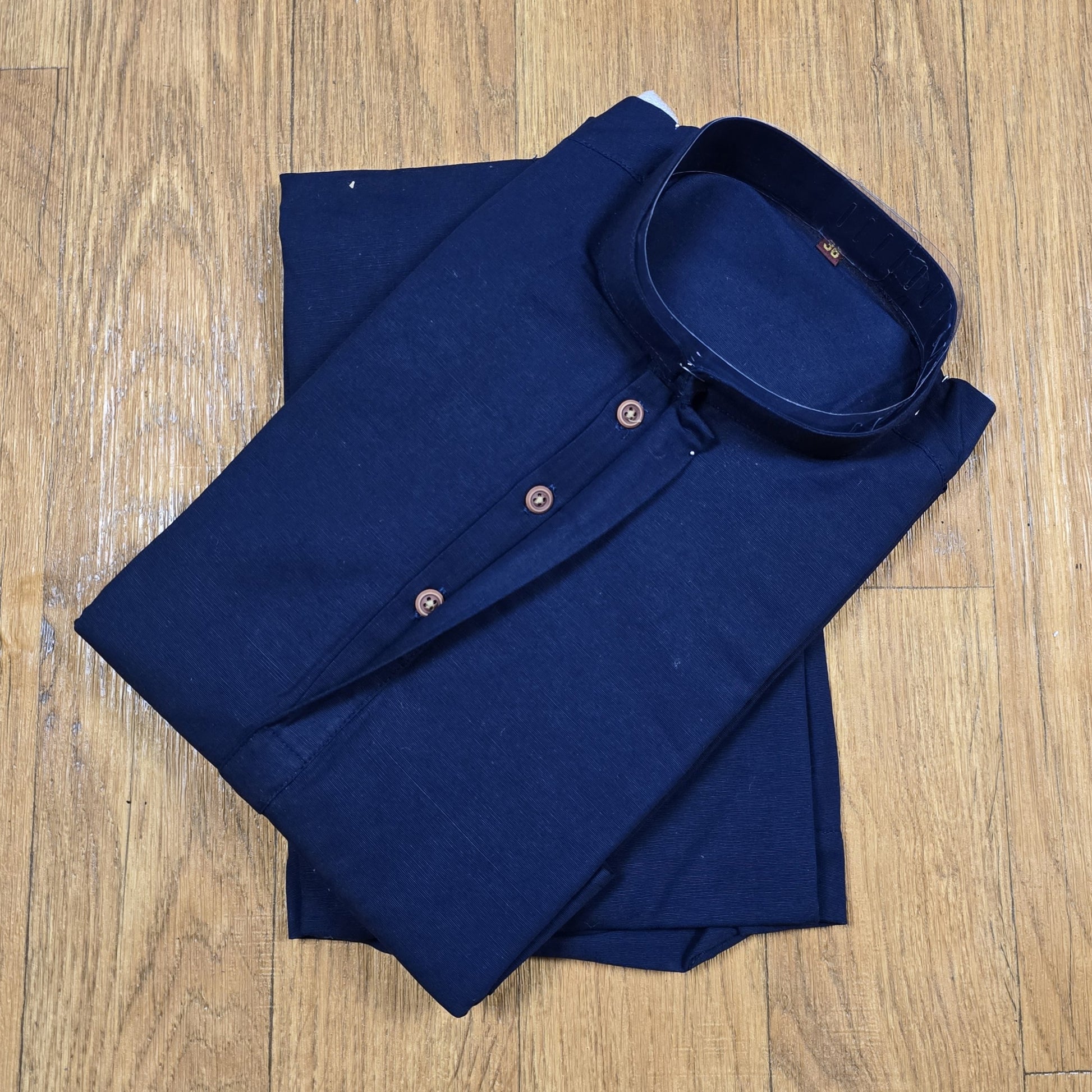 Folded Navy Blue mandarin collar Kurta on wooden floor