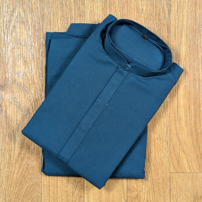 Folded Ocean Blue mandarin collar kurtawith brown buttons on wooden floor