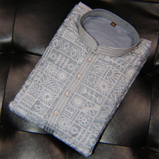 Folded light blue shirt with geometric pattern on a dark leather surface