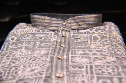 Close-up of a patterned shirt with buttons on a dark background