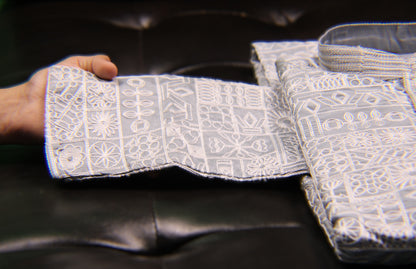 Close-up of embroidered fabric with intricate patterns on a dark background