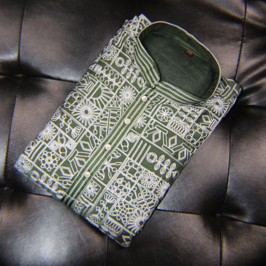 Green and white patterned shirt on a dark leather surface